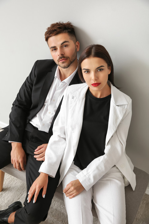 stylish-young-couple-sitting-bench-near-white-wall.jpeg