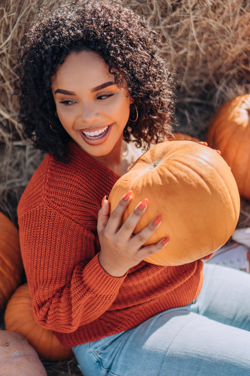 happy-curly-hair-young-woman-holding-pumpkin_t20_b8evx9.jpeg