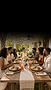Friends dining together at a long outdoor table.