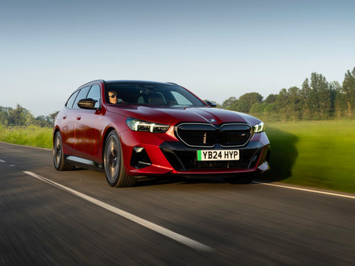 Dynamic front 3/4 shot of a red BMW i5 M60 Touring