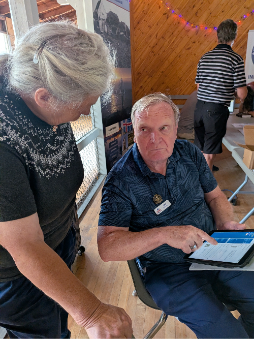 Eigil discussing Icelandic genealogy with a festival attendee. Image shared by author. 