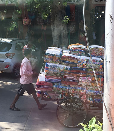 Local transportation of many fabric sheets through the streets of Jaipur