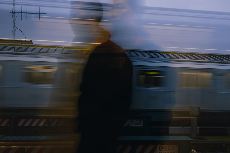 A blurred image of a man with a blurred train in the background