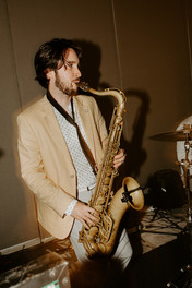 A saxophonist playing tenor saxophone at a party