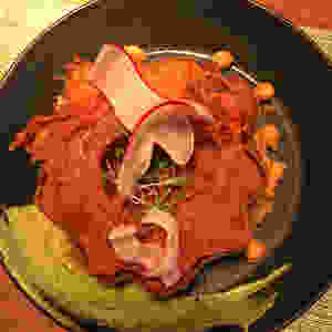 modern take on acorn squash dish with rich, green dipping sauce and a flower garnish