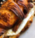 handmade croissant stuffed with fried egg and meats