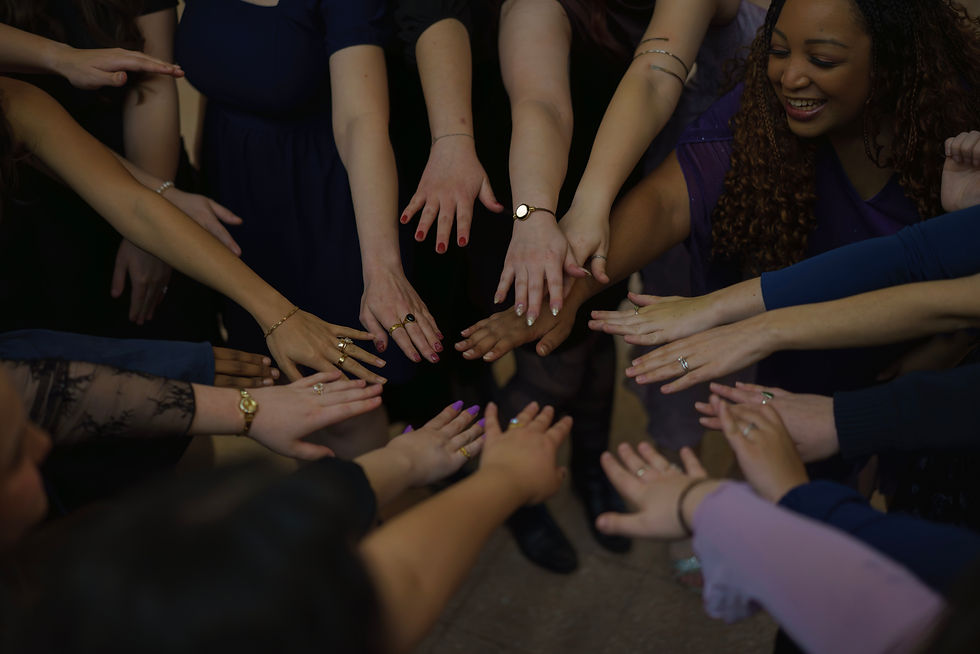 Members putting their hands in the circle for a group chant