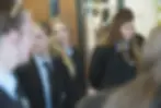 Candid photography of three students in school uniforms walking through a hallway. They appear calm and focused, reflecting a typical day at an academic institution.
