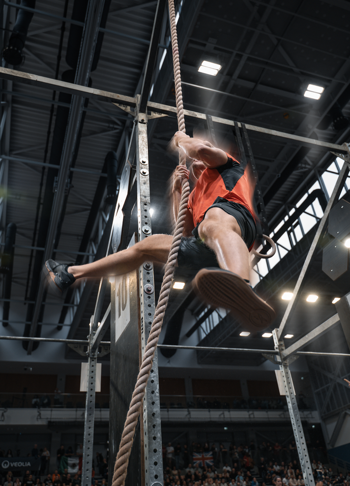 Male functional fitness athlete climbing a rope during the 2024 Functional Fitness World Championships in Hungary.