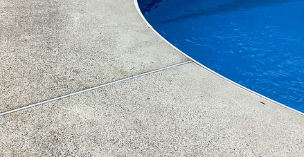 General surface wear and faded concrete along pool edge