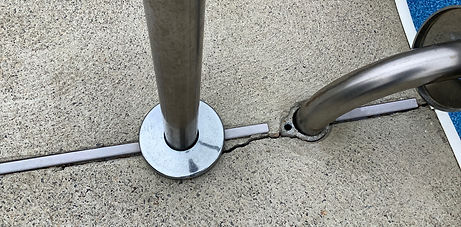Cracking around handrail base at expansion joint intersection on concrete pool deck