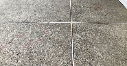 Wide view of pool deck with surface staining and general wear