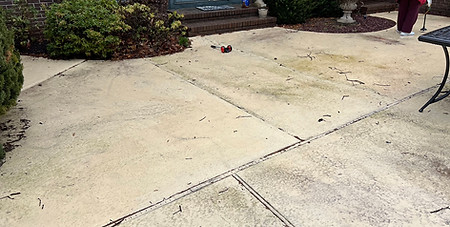 Large patio sections showing uneven discoloration and embedded dirt buildup
