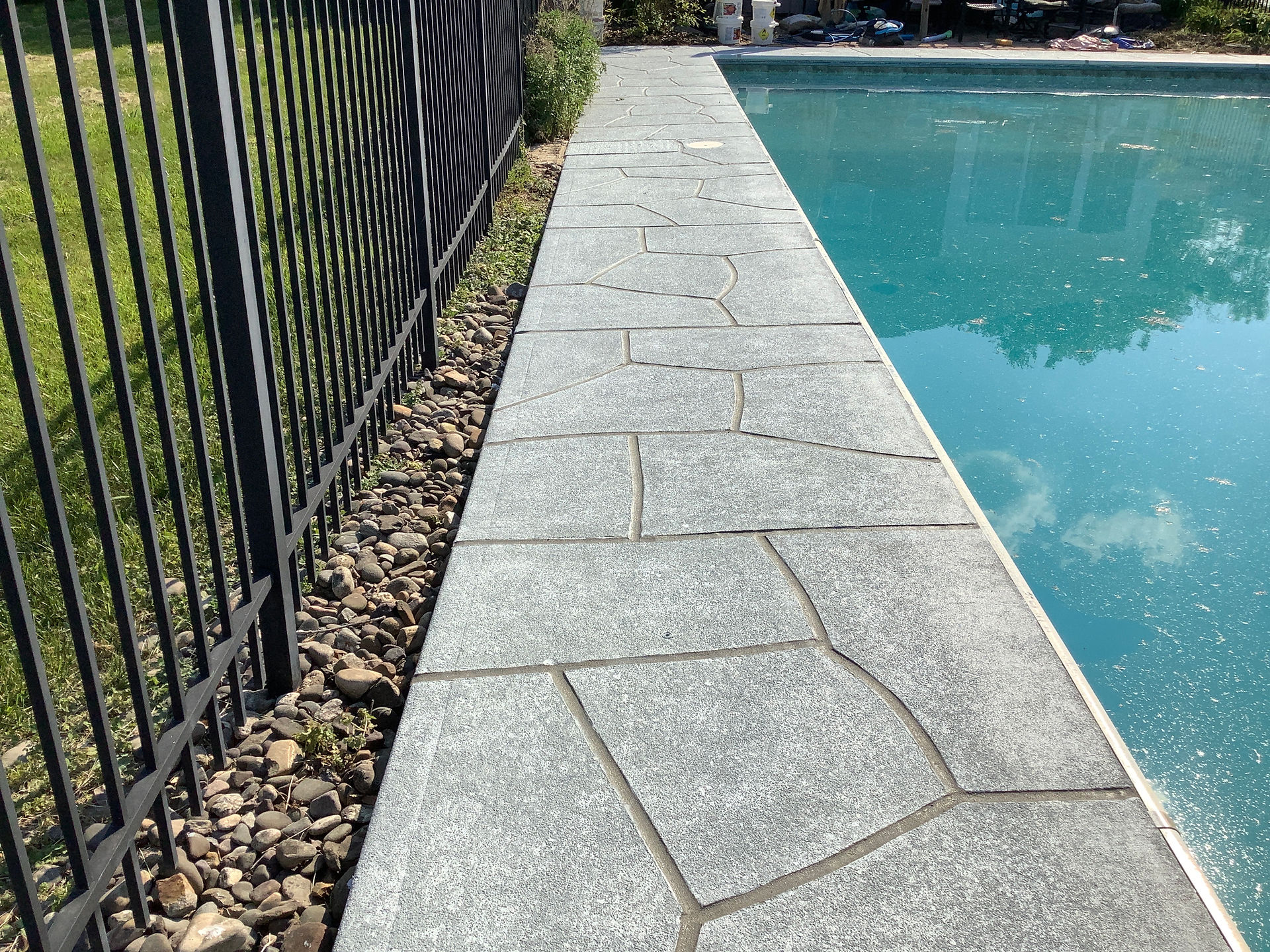 RenuKrete stone look concrete pool deck in a landscaped backyard