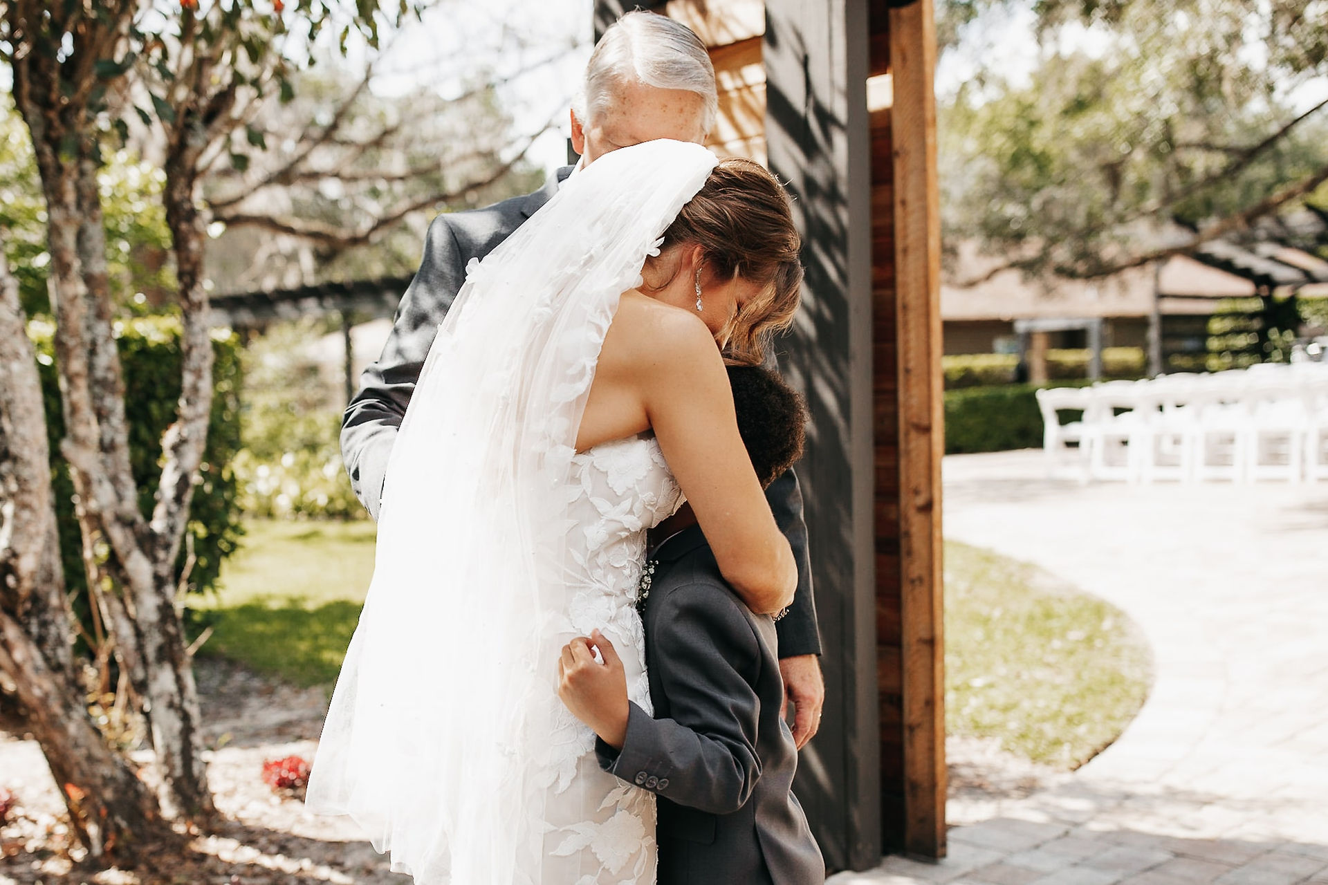 Bride hugging her kid and father