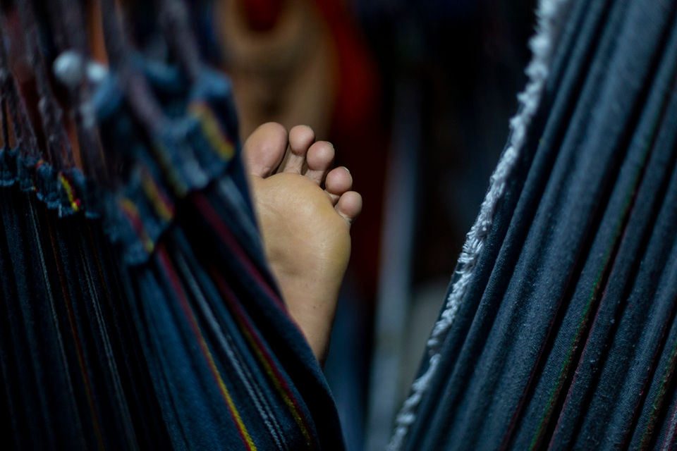 Detalhe do pé de um folião, descansando deitado na rede dentro do barco que leva os torcedores de Manaus a Parintins.