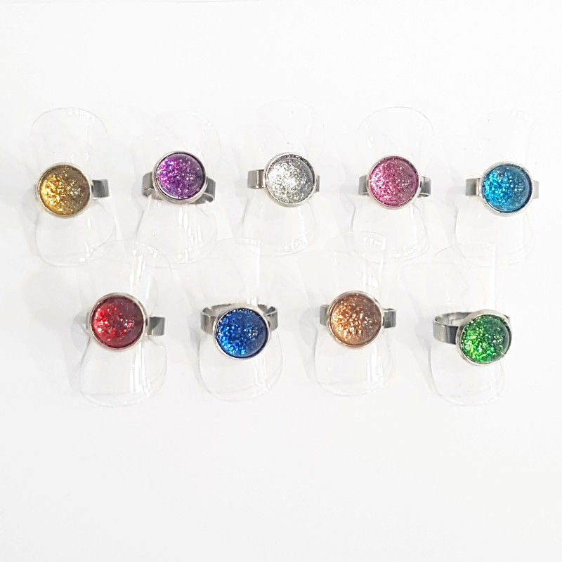 9 bagues réglables avec un cabochon en verre à paillettes. Couleur au choix