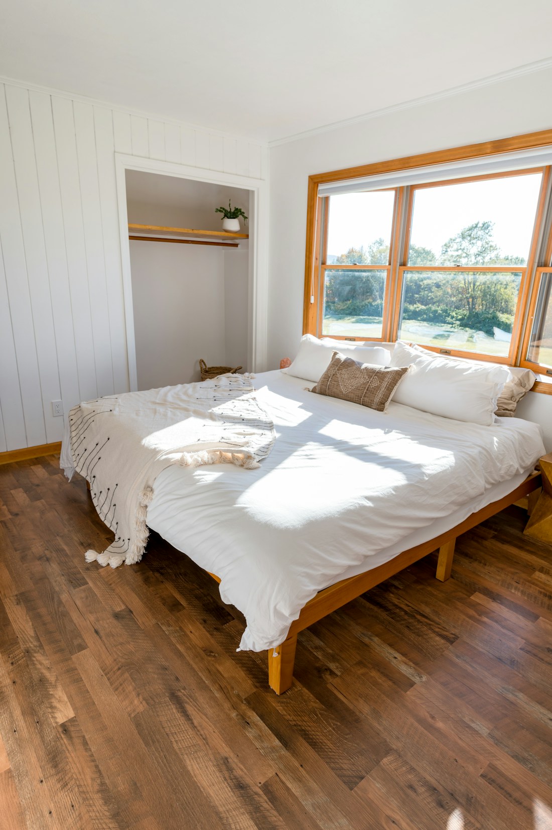 Fresh white bed linen in a bright, naturally lit bedroom