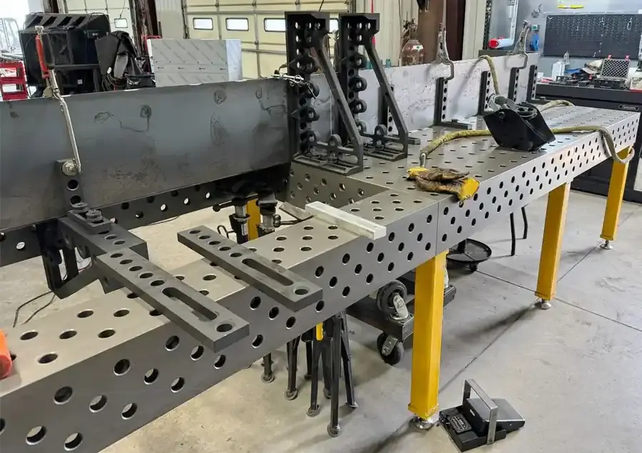 Close-up of D28 welding table hole pattern showing accurate machining and 100mm grid spacing