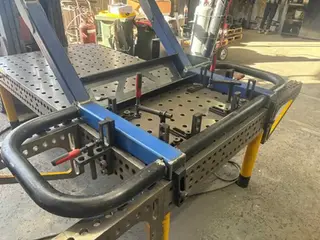 System 28 modular welding table fixture setup with clamps used in fabrication workshop