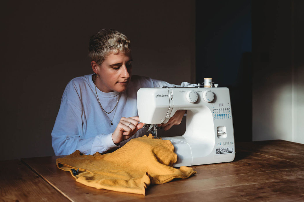 Borrower using a sewing machine in their living room