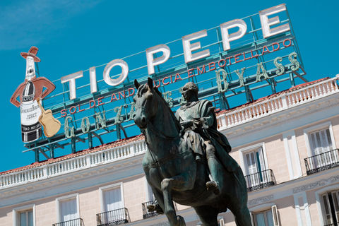 Digital color photograph of a Spanish plaza featuring a sign saying Tio Pepe