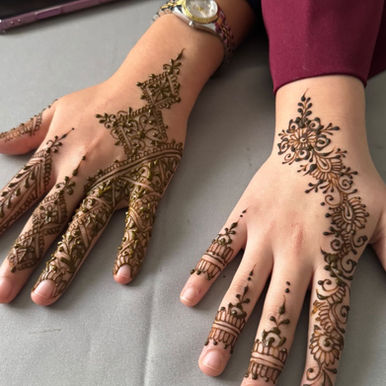 handen op tafel gelegd en versierd met henna. 