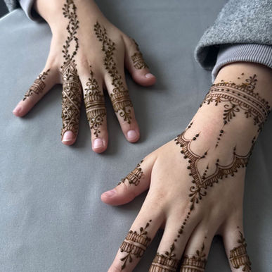 handen op tafel gelegd en versierd met henna. 