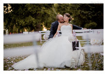 Marié embrassant la joue de sa mariée dans le parc.