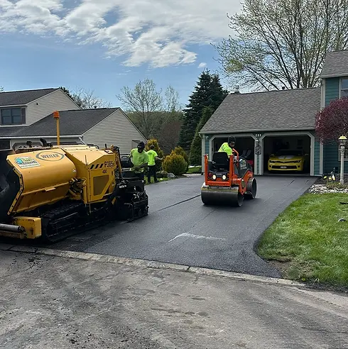asphalt paving contractors near syracuse ny residential driveway paving in progress.webp