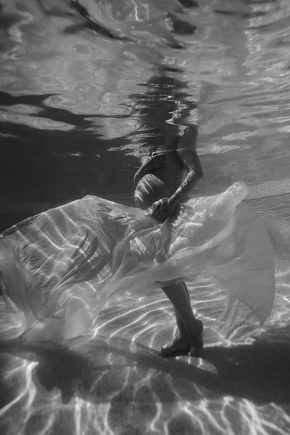 underwater maternity photoshoot in a pool black and white
