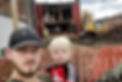 Photo of the founder and his son in front of a building being demolished