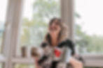 Female entrepreneur laughing and looking away from camera, holding coffee mugs