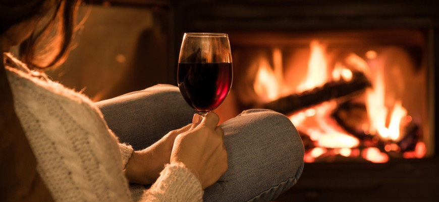 young-woman-sitting-at-home-by-the-fireplace-and-drinking-a-red-wine-picture-id846414424 (
