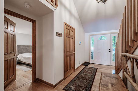 Hallway in the entry showing wood flooring and part of the stairway to upper level in the Long Lake vacation rental