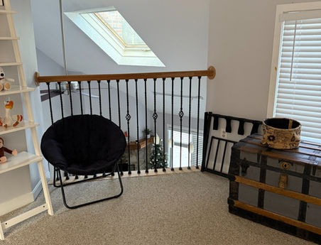 Safety gate, chest and chair in the upper loft area of Alpine Escape vacation rental Bridgton Maine
