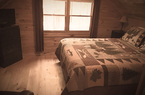 Cozy bedroom with pictures of deer on the spread in another REW Lake Rentals vacation property