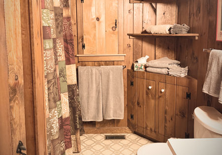 Bathroom with all pine wood walls, toilet and shower in the Kezar Lake vacation rental