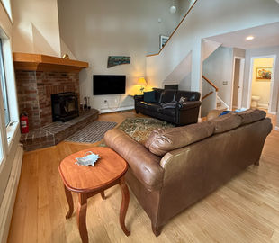 Sofa and end table with wood floors in Fireside Retreat vacation rental in Bridgton Maine