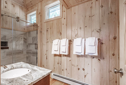 Pine bathroom with sink, shower. An REW Lake Rental in Bridgton Maine vacation home.