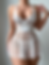Sheer white lace babydoll with intricate floral patterns, a satin ribbon bow, and matching thong, ideal for bridal nightwear