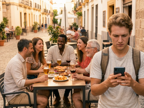 Extranjero aprendiendo español busca el significado de una expresión mientras escucha una conversación en un bar.