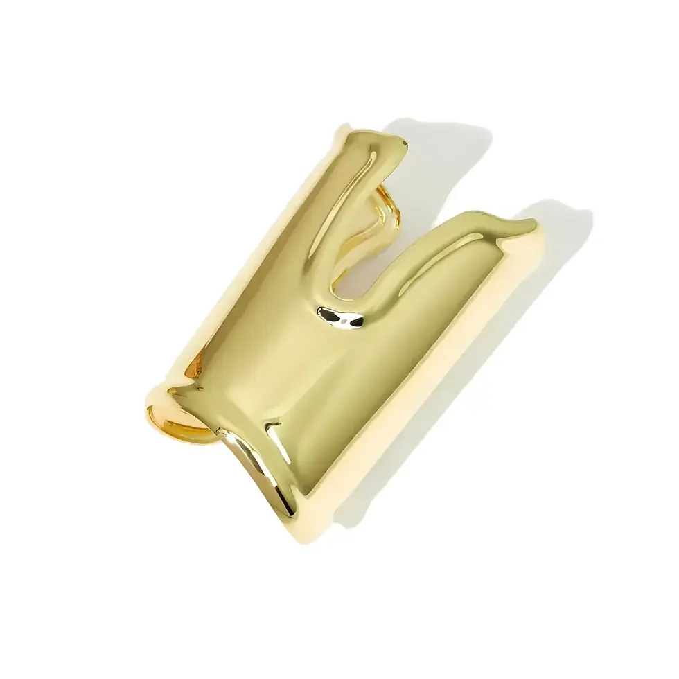 O ângulo evidencia a silhueta longa de ouro polido, o recorte frontal em "U" e a abertura posterior do aro rígido.