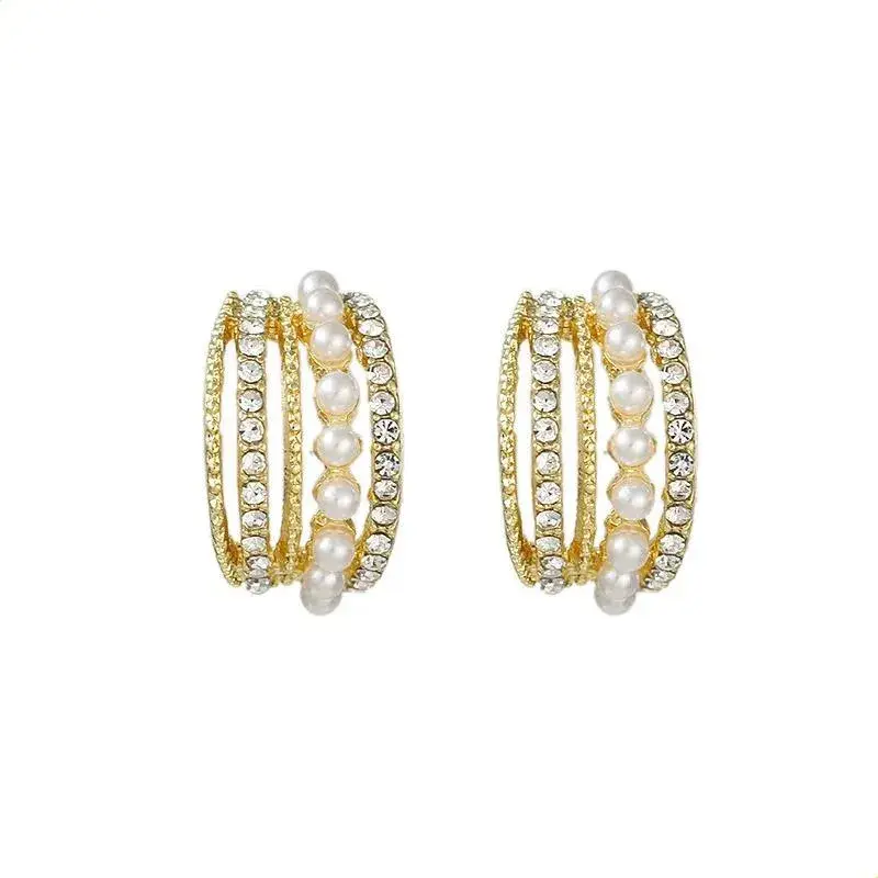 Par de brincos estilo meia argola multi-row em banho de ouro 18k com pérolas shell e microzircónias sobre fundo branco