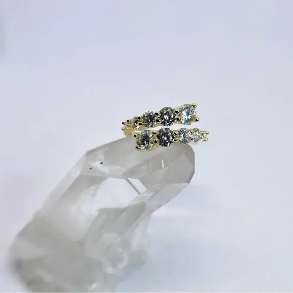 Miniatura: Anel dourado com design transpassado (aro aberto), apresentando duas fileiras de pedras zircônias transparentes de lapidação