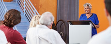 senior-woman-at-podium-chairing-neighborhood-meeti-2026-03-10-03-16-35-utc.jpg