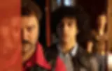 Cena do filme Peter von Kant dirigido por François Ozon. Em cena: Denis Ménochet (Peter / Petra), Khalil Ben Gharbia (Amir Ben Salem / Karin) e Stefan Crepon (Karl / Marlene)