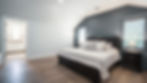 Modern bedroom with dark accent wall and hardwood floors