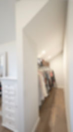 Organized walk-in closet with clothes on hangers