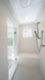 Modern white walk-in shower with bench and black fixtures